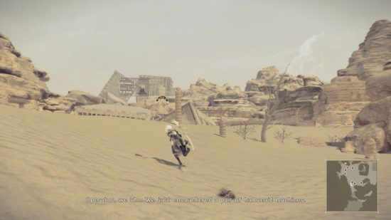 2B atravessando o deserto com rochas e prédios em ruínas à distância em uma captura de tela de Nier Automata para Nintendo Switch.