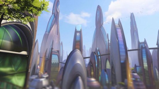 Um mapa de Overwatch 2 mostrando uma cena mostrando edifícios futuristas curvos subindo alto no céu.