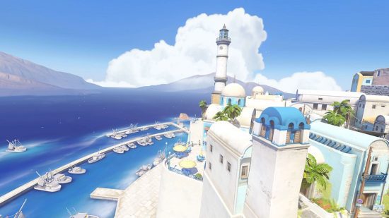 Um mapa de Overwatch 2 mostrando uma cena de uma ilha grega com densas construções brancas e um longo mar azul ao longe.