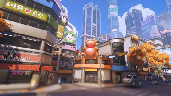 Modos de jogo Overwatch 2 - Um mapa de Overwatch 2 mostrando uma cena de arranha-céus altos, pequenas lojas de esquina e uma cidade movimentada em geral