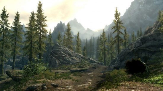 Dragão de Skyrim: Pinheiros altos alinham um caminho empoeirado com pedras pontilhadas e um monte pedregoso à frente, com montanhas altas e silhuetas abaixo de um céu dourado