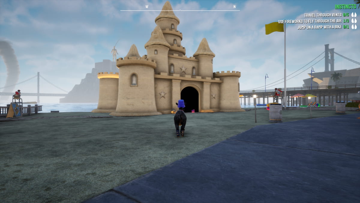 Cabra parada na frente de um castelo de areia gigante.