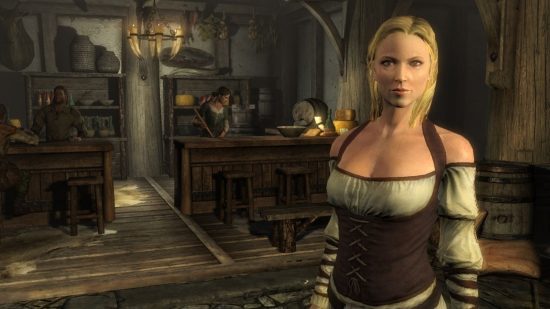 Seguidores de Skyrim: uma mulher loira está em uma loja em primeiro plano com outra varrendo ao fundo atrás de um balcão de madeira em uma captura de tela de Skyrim.